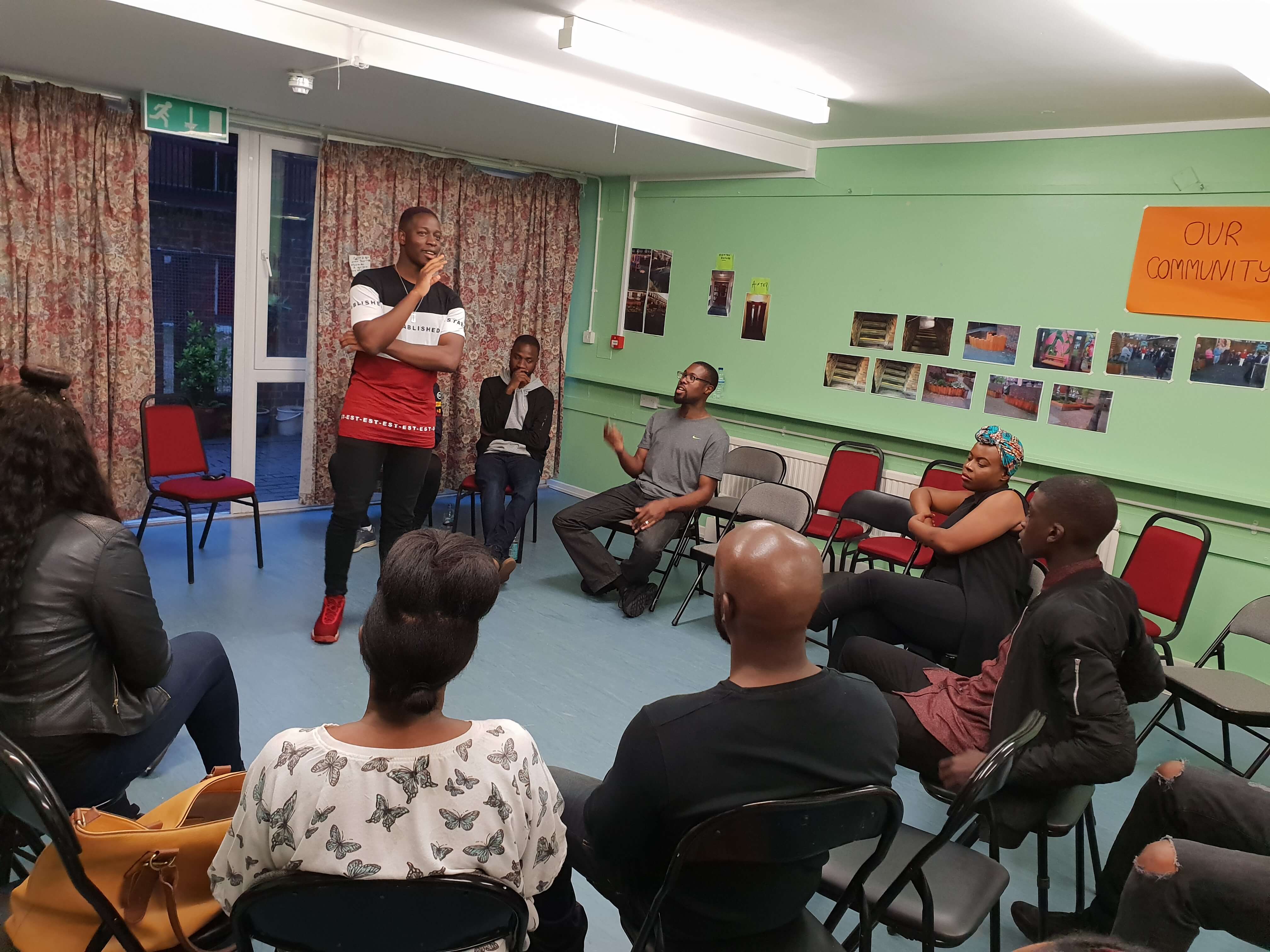 man leading a discussion with a group of people sitting in a circle